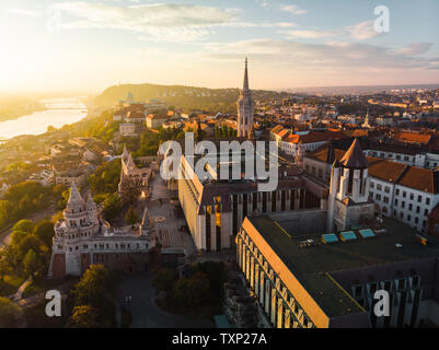 Luftaufnahme der Fischerhochburg und Matthias Kirche von oben in Budapest bei Sonnenaufgang im Herbst mit dramatischen Himmel (Budapest, Ungarn, Europa) Stockfoto