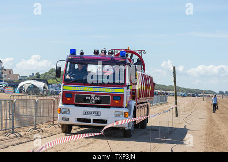 Vorderansicht eines britischen Fire Engine, Feuerwehr und Rettung Appliance, fahren am Strand, im Sommer, während einer speziellen Veranstaltung in Weston-super-Mare, Großbritannien. Stockfoto