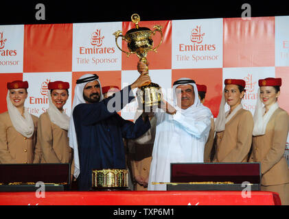 Der Herrscher von Dubai, Scheich Mohammed Bin Rashid Al Maktoum (L) übergibt die Trophäe an den stellvertretenden Herrscher von Dubai und Inhaber der gewinnende Pferd, Invasor, Sheikh Hamdan Bin Rashid Al Maktoum an der 12 Dubai World Cup, am 31. März 2007. Der eine Tag, sieben Rennen Dubai World Cup ist das reichste Pferderennen der Welt mit einem Gesamtgeldbeutel über 21 Millionen US-Dollar wert. (UPI Foto/Kamal Moghrabi) Stockfoto