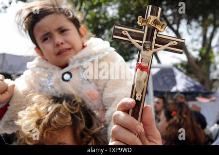 Ägyptische koptische Christen demonstrieren, während ein Kruzifix während eines Protestes außerhalb des ägyptischen Staatsfernsehen Gebäude in Kairo am 10. März 2011. Mindestens 13 Menschen wurden in den konfessionellen Auseinandersetzungen, der ausbrach, als 1.000 Christen versammelten die Verbrennung einer Kirche zu protestieren, die in der vergangenen Woche getötet. UPI Mohammed Hosam Stockfoto