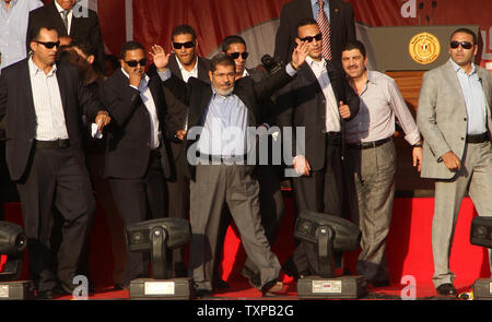 Von Bodyguards flankiert, Ägyptischen islamistischen Präsidenten Mohamed Morsi (C) Adressen Zehntausende Ägypter in Kairo's Iconic Tahrir-platz am 29. Juni 2012. Morsi würdigte Ägyptens Muslime und Christen gleichermaßen und symbolisch schwor sich als erste gewählte zivile Präsident des Landes. UPI/Ahmed Jomaa Stockfoto