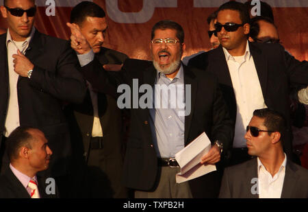 Von Bodyguards flankiert, Ägyptischen islamistischen Präsidenten Mohamed Morsi (C) Adressen Zehntausende Ägypter in Kairo's Iconic Tahrir-platz am 29. Juni 2012. Morsi würdigte Ägyptens Muslime und Christen gleichermaßen und symbolisch schwor sich als erste gewählte zivile Präsident des Landes. UPI/Ahmed Jomaa Stockfoto