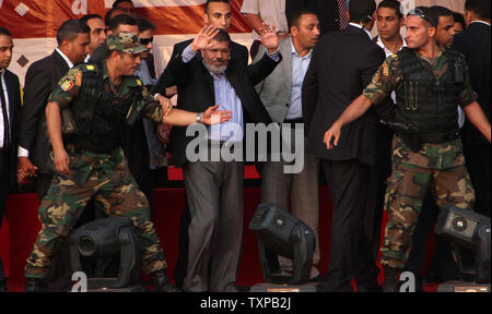 Von Bodyguards flankiert, Ägyptischen islamistischen Präsidenten Mohamed Morsi (C) Adressen Zehntausende Ägypter in Kairo's Iconic Tahrir-platz am 29. Juni 2012. Morsi würdigte Ägyptens Muslime und Christen gleichermaßen und symbolisch schwor sich als erste gewählte zivile Präsident des Landes. UPI/Ahmed Jomaa Stockfoto