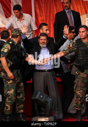 Von Bodyguards flankiert, Ägyptischen islamistischen Präsidenten Mohamed Morsi (C) Adressen Zehntausende Ägypter in Kairo's Iconic Tahrir-platz am 29. Juni 2012. Morsi würdigte Ägyptens Muslime und Christen gleichermaßen und symbolisch schwor sich als erste gewählte zivile Präsident des Landes. UPI/Ahmed Jomaa Stockfoto