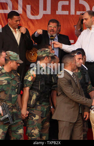 Von Bodyguards flankiert, Ägyptischen islamistischen Präsidenten Mohamed Morsi (C) Adressen Zehntausende Ägypter in Kairo's Iconic Tahrir-platz am 29. Juni 2012. Morsi würdigte Ägyptens Muslime und Christen gleichermaßen und symbolisch schwor sich als erste gewählte zivile Präsident des Landes. UPI/Ahmed Jomaa Stockfoto