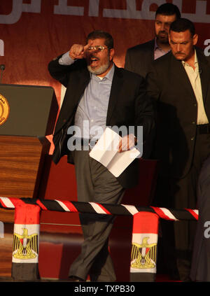 Von Bodyguards flankiert, Ägyptischen islamistischen Präsidenten Mohamed Morsi (C) Adressen Zehntausende Ägypter in Kairo's Iconic Tahrir-platz am 29. Juni 2012. Morsi würdigte Ägyptens Muslime und Christen gleichermaßen und symbolisch schwor sich als erste gewählte zivile Präsident des Landes. UPI/Ahmed Jomaa Stockfoto