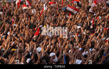 Ägypter heben die Hand und skandieren Parolen, wie Sie sammeln für eine Rede, die der designierte Präsident Mohammed Morsi auf dem Tahrir-Platz in Kairo, Ägypten, 29. Juni 2012. Morsi würdigte Ägyptens Muslime und Christen gleichermaßen und symbolisch schwor sich als erste gewählte zivile Präsident des Landes. UPI/Ahmed Jomaa Stockfoto