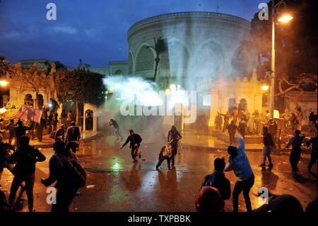 Ägyptische Demonstranten werfen Steine auf den Präsidentenpalast in Kairo in Ägypten, am 1. Februar 2013, als die Menschen auf die Straßen über dem Land in eine Show der Opposition gegen Mursi und seinen Muslimischen Bruderschaft regierende Partei nahm. Ägyptische Sicherheit verwendet, Wasserwerfer und schossen in die Luft, als die Demonstranten Benzinbomben und Steine auf das Gelände des Präsidentenpalastes warf, sagte ein Sprecher des Präsidenten. UPI/Ahmed Jomaa Stockfoto