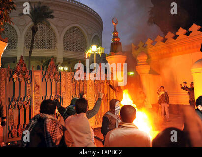 Ägyptische Demonstranten werfen Steine auf den Präsidentenpalast in Kairo in Ägypten, am 1. Februar 2013, als die Menschen auf die Straßen über dem Land in eine Show der Opposition gegen Mursi und seinen Muslimischen Bruderschaft regierende Partei nahm. Ägyptische Sicherheit verwendet, Wasserwerfer und schossen in die Luft, als die Demonstranten Benzinbomben und Steine auf das Gelände des Präsidentenpalastes warf, sagte ein Sprecher des Präsidenten. UPI/Ahmed Jomaa Stockfoto