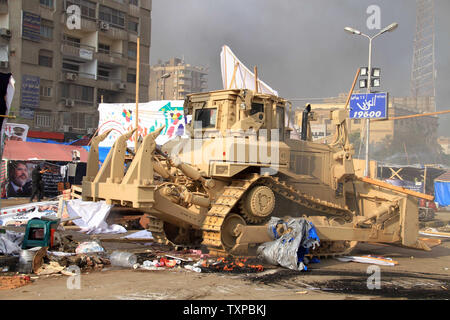 Eine ägyptische Militär bulldozer zerlegt Kairos Al-Nahda square Protest Camp nach ägyptische Sicherheitskräfte Unterstützer von Ägyptens gestürzten Präsidenten Mohamed Morsi in zwei große Lager in der ägyptischen Hauptstadt am 14 August, 2013 verteilt. Sicherheitskräfte ein Vorgehen gegen die Protest Camps, die schnell in ein Blutbad verwandelt mit Dutzenden Toten. Der Ausnahmezustand erklärt wurde. UPI/Karem Ahmed Stockfoto