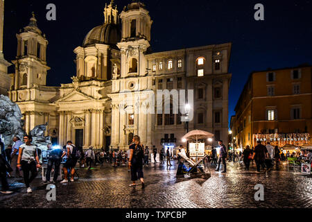 Bis spät in die Nacht auf der bunt beleuchteten Piazza Navona, mit Touristen, Künstler und Händler, Souvenirs, in Rom, Italien. Stockfoto