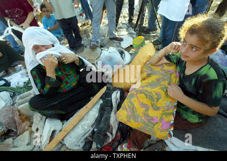 Eine palästinensische Frau weint auf den Trümmern ihrer zerstörten Haus, nachdem ein israelischer Einsatz in Khan Younis Flüchtlingslager am 25. September 2004 im südlichen Gazastreifen. Die israelische Armee mindestens 25 palästinensische Häuser vor Gestern Rückzug aus dem Bereich zerstört, Palästinensische Sicherheitskräfte sagte. (UPI Foto/Ismael Mohamad) Stockfoto