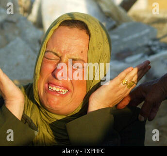 Eine palästinensische Frau weint auf den Trümmern ihrer zerstörten Haus, nachdem ein israelischer Einsatz in Khan Younis Flüchtlingslager am 25. September 2004 im südlichen Gazastreifen. Die israelische Armee mindestens 25 palästinensische Häuser vor Gestern Rückzug aus dem Bereich zerstört, Palästinensische Sicherheitskräfte sagte. (UPI Foto/Ismael Mohamad) Stockfoto