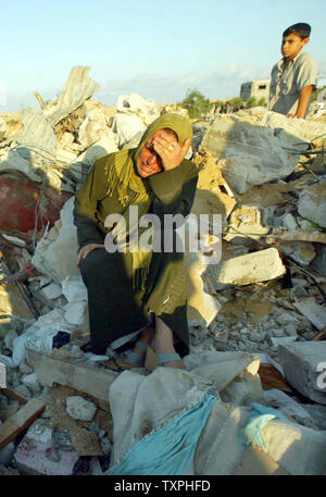 Eine palästinensische Frau weint auf den Trümmern ihrer zerstörten Haus, nachdem ein israelischer Einsatz in Khan Younis Flüchtlingslager am 25. September 2004 im südlichen Gazastreifen. Die israelische Armee mindestens 25 palästinensische Häuser vor Gestern Rückzug aus dem Bereich zerstört, Palästinensische Sicherheitskräfte sagte. (UPI Foto/Ismael Mohamad) Stockfoto