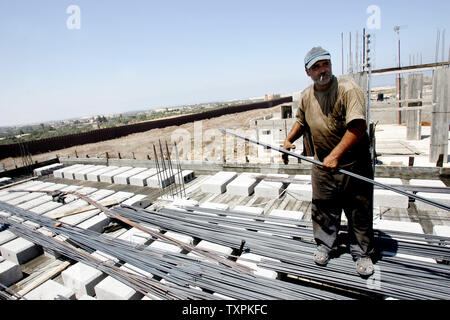 Eine palästinensische Arbeiter baut ein Haus, das durch die israelische Armee während der Intifada zerstört wurde direkt an der Grenze zwischen Ägypten und dem Rafah Flüchtlingslager am 31. August 2005, im südlichen Gazastreifen. Mehrere palästinensische Familien, deren Häuser durch die israelische Armee zerstört wurden, haben begonnen, an der Grenze mit Ägypten zurück zum Wiederaufbau es Wohnungen. (UPI Foto/Ismael Mohamad) Stockfoto