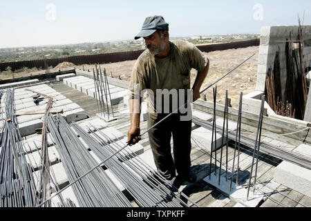 Eine palästinensische Arbeiter baut ein Haus, das durch die israelische Armee während der Intifada zerstört wurde direkt an der Grenze zwischen Ägypten und dem Rafah Flüchtlingslager am 31. August 2005, im südlichen Gazastreifen. Mehrere palästinensische Familien, deren Häuser durch die israelische Armee zerstört wurden, haben begonnen, an der Grenze mit Ägypten zurück zum Wiederaufbau es Wohnungen. (UPI Foto/Ismael Mohamad) Stockfoto