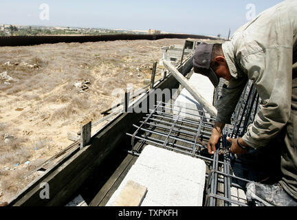 Eine palästinensische Arbeiter baut ein Haus, das durch die israelische Armee während der Intifada zerstört wurde direkt an der Grenze zwischen Ägypten und dem Rafah Flüchtlingslager am 31. August 2005, im südlichen Gazastreifen. Mehrere palästinensische Familien, deren Häuser durch die israelische Armee zerstört wurden, haben begonnen, an der Grenze mit Ägypten zurück zum Wiederaufbau es Wohnungen. (UPI Foto/Ismael Mohamad) Stockfoto