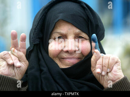 Eine palästinensische Frau zeigt mit dem Finger gebeizt mit unauslöschbarer Tinte, nachdem sie ihre Stimmen in den palästinensischen Wahlen zu einem Wahllokal in Rafah im Gazastreifen Am 25. Januar 2006 abgeben. Umfragen in der West Bank und im Gazastreifen in der nur zweite Wahl in den Gazastreifen eröffnet - auf der Grundlage des Europäischen Parlaments seit der Gründung der Palästinensischen Autonomiebehörde. Die Umfrage wird Siehe die regierende Fatah faction der erste große Test seinen Einfluß auf die radikal-islamische Bewegung Hamas. (UPI Foto/Ismael Mohamad) Stockfoto