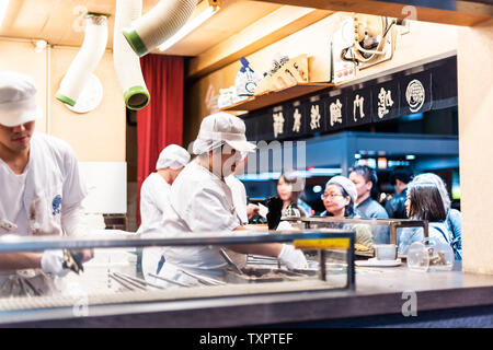 Osaka, Japan - 13. April 2019: Minami Namba berühmten Straße mit Restaurant, Shop und Küchenchef Menschen kochen Fisch Dessert namens Taiyaki Stockfoto