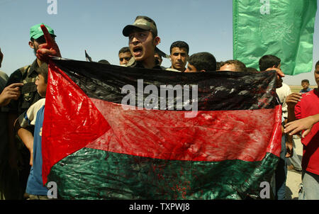 Eine Demonstrantin hält ein Blut - palästinensische Flagge während einer Demonstration gegen die Belagerung im Gazastreifen durchnäßt, am Grenzübergang Karni, zwischen Israel und Gaza, am 22. Mai 2008. Einen Palästinenser getötet und 17 verletzt worden, als israelische Truppen im Gazastreifen auf Demonstranten, die gegen die lähmende Blockade des Gebietes gezeigt gefeuert. (UPI Foto/Ismael Mohamad) Stockfoto