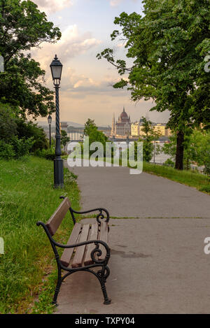 Einer Bank in einem Park in Budapest mit dem Ungarischen Parlament Stockfoto