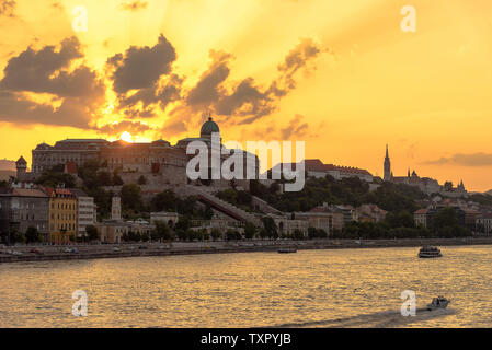 Der Königliche Palast in Budapest bei Sonnenuntergang mit Booten auf der Donau Stockfoto