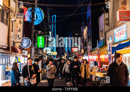 Osaka, Japan - 13. April 2019: Minami Namba Straße mit Menschen zu Fuß in dunkler Nacht und beleuchteten Gebäuden mit bunten Zeichen Stockfoto