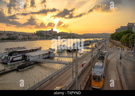 Angedockten Boote, die Straßenbahn und den Königlichen Palast in Budapest bei Sonnenuntergang mit der Donau Stockfoto