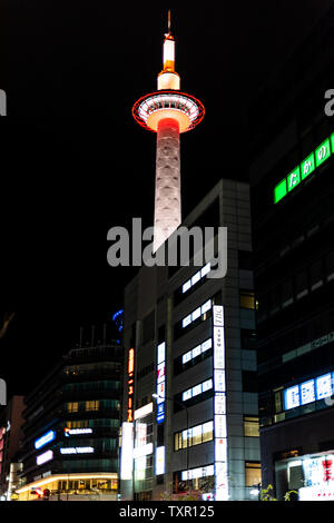 Kyoto, Japan - 13. April 2019: Vertikale Stadtlandschaft während der Tag der großen Stadt mit Turm in der Nähe von Station während dunkle schwarze Nacht und beleuchteten Gebäuden Stockfoto