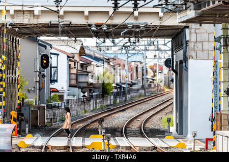 Kyoto, Japan - 14 April, 2019: KEIHAN U-Bahn U-Bahn Titel mit Frau Kreuzung Straße während des Tages in der Nähe von Tofukuji Station Stockfoto