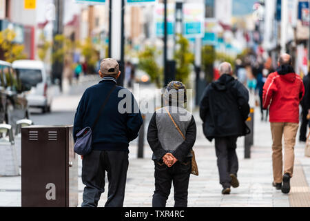 Nara, Japan - 14 April, 2019: Zurück von Menschen Touristen senior Paar zu Fuß auf der Straße Straße Straße in der Innenstadt von Stadt in Richtung Park Stockfoto