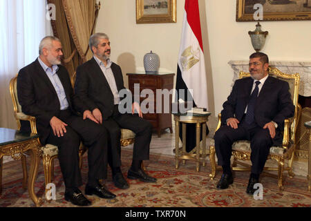 Der ägyptische Präsident Mohamed Morsi (R) trifft mit dem palästinensischen Ministerpräsidenten Ismail Haniyeh (L) und palästinensischen Führer der Hamas Khaled Meshaal die Frage der palästinensische Aussöhnung in Kairo am 17. Juni 2013 zu diskutieren. UPI/Palästinensische PM Medien Stockfoto