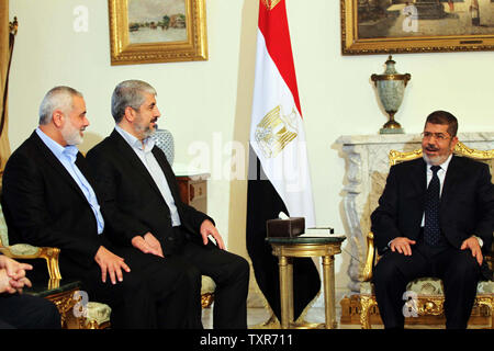 Der ägyptische Präsident Mohamed Morsi (R) trifft mit dem palästinensischen Ministerpräsidenten Ismail Haniyeh (L) und palästinensischen Führer der Hamas Khaled Meshaal die Frage der palästinensische Aussöhnung in Kairo am 17. Juni 2013 zu diskutieren. UPI/Palästinensische PM Medien Stockfoto