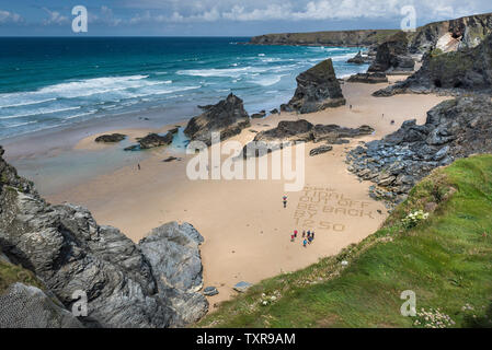 Eine Warnung in den Sand geschrieben am Strand an der robusten, spektakuläre Bedruthan Steps auf der nördlichen Küste von Cornwall. Stockfoto