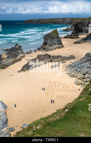 Eine Warnung in den Sand geschrieben am Strand an der robusten, spektakuläre Bedruthan Steps auf der nördlichen Küste von Cornwall. Stockfoto