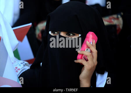 Palästinensischen Braut sprechen Sie Ihr Telefon, während einer Messe Hochzeit für 2000 Paare in Gaza-stadt 31. Mai 2015 teilnehmen. Fast 2000 palästinensische Paare in einer Zeremonie von der türkischen Regierung finanziert und von der Hamas unterstützte verheiratet waren, palästinensische Beamte. Foto von Ismael Mohamad/UPI Stockfoto