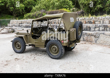 Ein Willys Jeep aus dem Zweiten Weltkrieg parkte auf dem Beton am Polgwidden Beach in Trebah Garden in Cornwall. Stockfoto