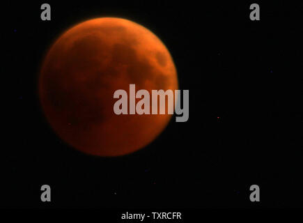 Der Mond wird rot bei einer totalen Mondfinsternis in palästinensische Gebiete im Gazastreifen, 27. Juli 2018. Sky Watcher um viel von der Welt freuen sich auf eine vollständige Mondfinsternis, der am längsten in diesem Jahrhundert werden. Foto von Ismael Mohamad/UPI Stockfoto