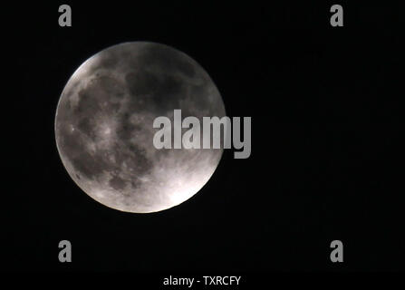 Der Mond wird rot bei einer totalen Mondfinsternis in palästinensische Gebiete im Gazastreifen, 27. Juli 2018. Sky Watcher um viel von der Welt freuen sich auf eine vollständige Mondfinsternis, der am längsten in diesem Jahrhundert werden. Foto von Ismael Mohamad/UPI Stockfoto