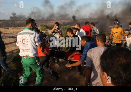 Palästinensische Demonstranten trägt ein verwundeter Mann vom Schauplatz von Auseinandersetzungen mit israelischen Truppen während Protest an der Israel-Gaza Grenze in Rafah, im südlichen Gazastreifen am 7. September 2018. Einen Palästinenser getötet und Dutzende verletzt, eine medizinische Quelle sagte. Foto von Ismael Mohamad/UP Stockfoto