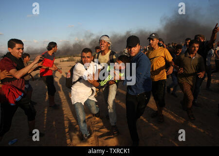 Palästinensische Demonstranten trägt ein verwundeter Mann vom Schauplatz von Auseinandersetzungen mit israelischen Truppen während Protest an der Israel-Gaza Grenze in Rafah, im südlichen Gazastreifen am 7. September 2018. Einen Palästinenser getötet und Dutzende verletzt, eine medizinische Quelle sagte. Foto von Ismael Mohamad/UP Stockfoto