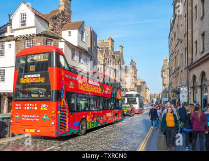 City Sightseeing open top tour bus und eine geschäftige Straße Szene auf Canongate, Teil der Royal Mile, in warmen April Sonnenschein. Edinburgh, Schottland, Großbritannien. Stockfoto