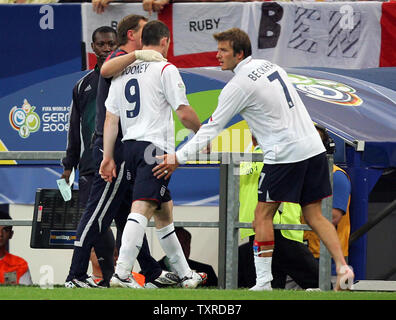 Der Engländer David Beckham Konsolen Wayne Rooney, wie er weg geht die Tonhöhe nach dem Senden nicht im Viertel Finale der FIFA Fußball-Weltmeisterschaft Deutschland 2006 in der Arena AufSchalke in Gelsenkirchen am 1. Juli 2006. Portugal gewann auf Strafenstößen 3-1 nach dem Spiel 0-0 der Verordnung gebunden war. (UPI Foto/Chris Brunskill) Stockfoto