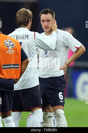 Der Engländer David Beckham Konsolen John Terry während das Elfmeterschießen im Viertelfinale Spiel der FIFA Fußball-Weltmeisterschaft Deutschland 2006 in der Arena AufSchalke in Gelsenkirchen am 1. Juli 2006. Portugal gewann auf Strafenstößen 3-1 nach dem Spiel 0-0 der Verordnung gebunden war. (UPI Foto/Chris Brunskill) Stockfoto