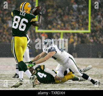 Green Bay Packers Quarterback Brett Favre (4) ist durch die Seattle Seahawks defensive nivellierten Angriff Craig Terrill (R) nach einem 11-Yard-Empfang zu festes Ende Donald Lee (86) Im zweiten Quartal des NFC Divisional Endspiel am Lambeau Field in Green Bay, Wisconsin am Januar, 12, 2008. Die Verpacker gewann 42-20. (UPI Foto/Brian Kersey) Stockfoto