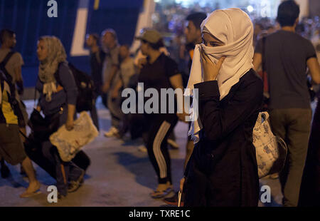 Migranten Aussteigen aus dem Fahrgastschiff "Tera Jet', nach Ihrer Reise von der Insel Lesbos in den Hafen von Piräus, in der Nähe von Athen, Griechenland am 1. September 2015. Ein weiterer 1.700 Migranten an Bord der Fähre nach Piräus von der Insel Mytilene angekommen, Migranten, die auf der östlichen Ägäis Inseln, mit mehr als 160.000 Landung in diesem Jahr bislang. Europa kämpft um seine größte Migration Krise seit dem Zweiten Weltkrieg zu reagieren, mit mehr als 300.000 Personen kommen in diesem Jahr. Foto von yuksel Pecenek/UPI Stockfoto