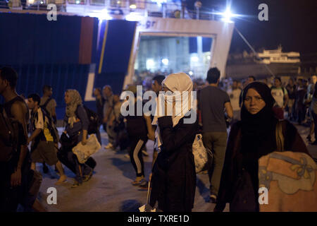 Migranten Aussteigen aus dem Fahrgastschiff "Tera Jet', nach Ihrer Reise von der Insel Lesbos in den Hafen von Piräus, in der Nähe von Athen, Griechenland am 1. September 2015. Ein weiterer 1.700 Migranten an Bord der Fähre nach Piräus von der Insel Mytilene angekommen, Migranten, die auf der östlichen Ägäis Inseln, mit mehr als 160.000 Landung in diesem Jahr bislang. Europa kämpft um seine größte Migration Krise seit dem Zweiten Weltkrieg zu reagieren, mit mehr als 300.000 Personen kommen in diesem Jahr. Foto von yuksel Pecenek/UPI Stockfoto