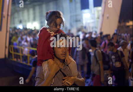 Migranten Aussteigen aus dem Fahrgastschiff "Tera Jet', nach Ihrer Reise von der Insel Lesbos in den Hafen von Piräus, in der Nähe von Athen, Griechenland am 1. September 2015. Ein weiterer 1.700 Migranten an Bord der Fähre nach Piräus von der Insel Mytilene angekommen, Migranten, die auf der östlichen Ägäis Inseln, mit mehr als 160.000 Landung in diesem Jahr bislang. Europa kämpft um seine größte Migration Krise seit dem Zweiten Weltkrieg zu reagieren, mit mehr als 300.000 Personen kommen in diesem Jahr. Foto von yuksel Pecenek/UPI Stockfoto