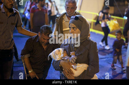 Migranten Aussteigen aus dem Fahrgastschiff "Tera Jet', nach Ihrer Reise von der Insel Lesbos in den Hafen von Piräus, in der Nähe von Athen, Griechenland am 1. September 2015. Ein weiterer 1.700 Migranten an Bord der Fähre nach Piräus von der Insel Mytilene angekommen, Migranten, die auf der östlichen Ägäis Inseln, mit mehr als 160.000 Landung in diesem Jahr bislang. Europa kämpft um seine größte Migration Krise seit dem Zweiten Weltkrieg zu reagieren, mit mehr als 300.000 Personen kommen in diesem Jahr. Foto von yuksel Pecenek/UPI Stockfoto