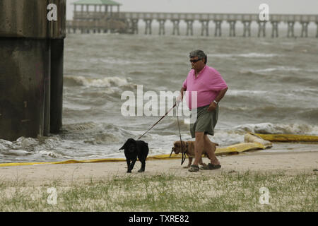 Roy Troendle Spaziergänge seine Hunde Schatten und Buster Vergangenheit einen Boom, der gebrochen hat und an Land entlang der train trestle in Bay St. Louis, Missouri gewaschen, am 2. Mai 2010. Bereitstellungsbereiche sind entlang der Golfküste in Zielmarktsegmenten identifizieren, Ziel- und Umwelt- und wirtschaftlich sensible Bereiche zu schützen, wie die Deepwater Horizon spill weiter zu verbreiten. Die mobile offshore Bohrinsel im Golf von Mexiko 52 km südöstlich von Venedig, Louisiana, in Flammen nach einer Explosion 10 April, 2010, Links 11 Arbeiter vermisst und vermutlich tot fortgerissen wurde. UPI/Bevil Knapp Stockfoto